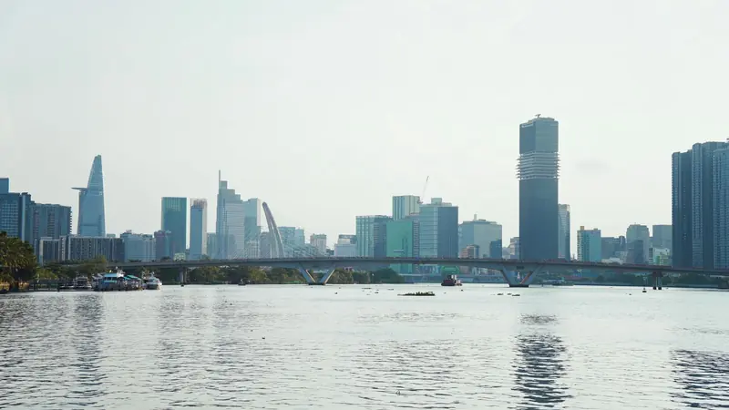 Ho Chi Minh City's skyline over the river, with a bridge in the foreground