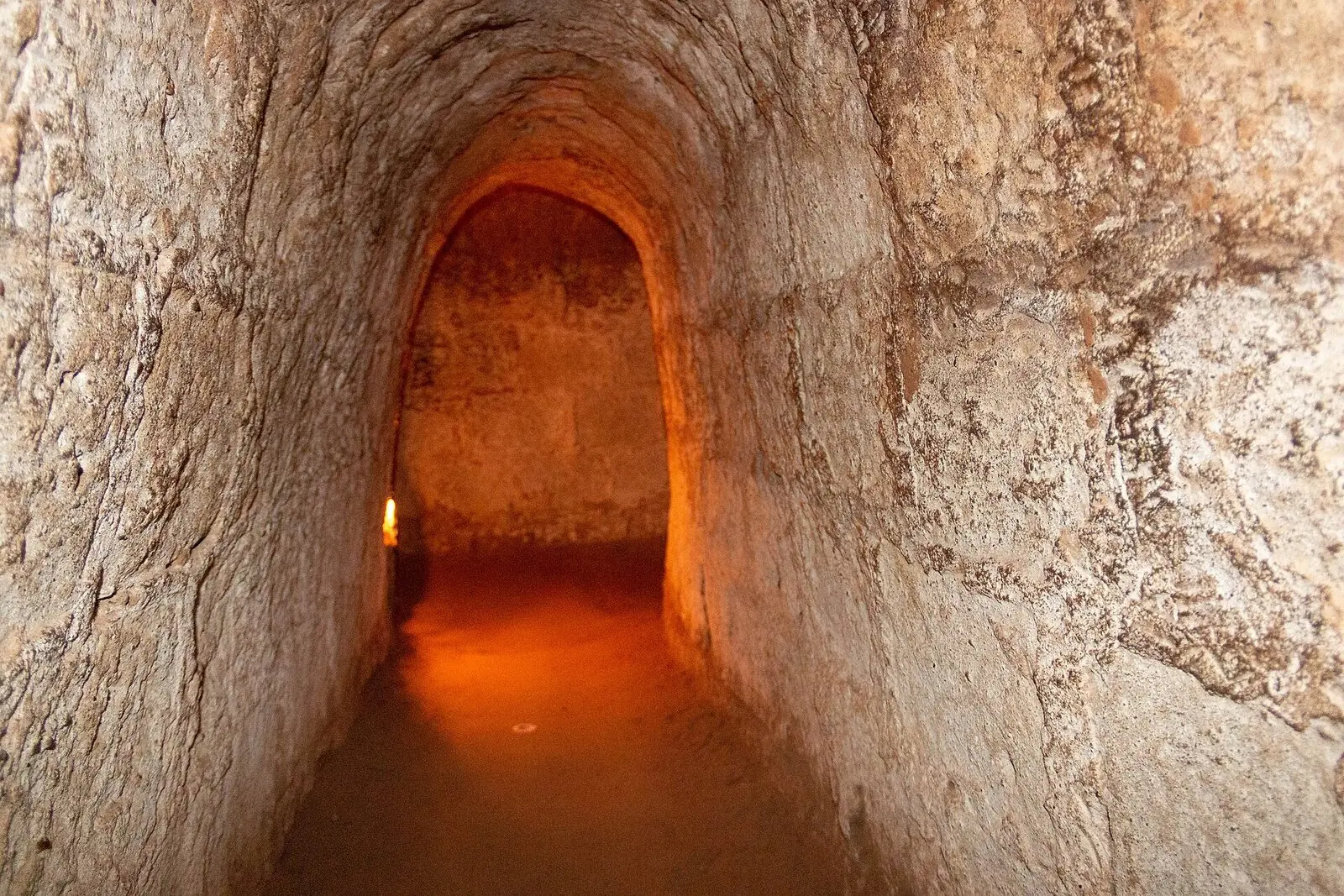 A lit, earth-walled section of the Cu Chi tunnels